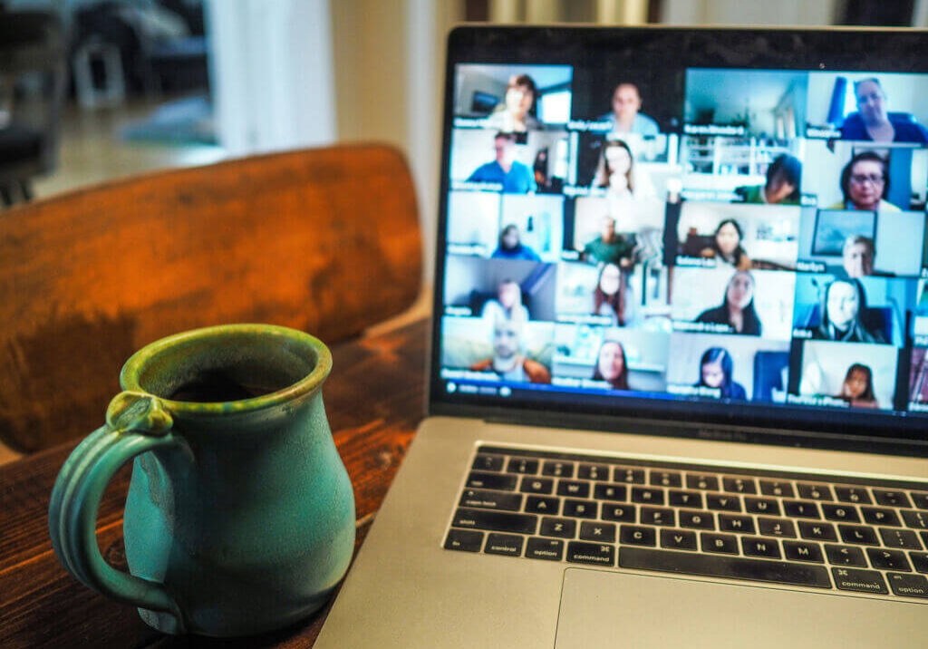 laptop with lots of people in a group meeting